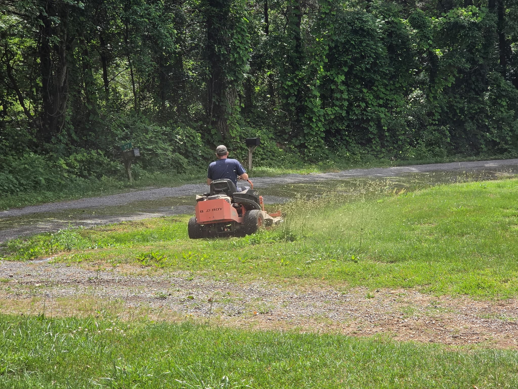 Roger Reed on a Bad Boy zero-turn mower cutting along a tree line